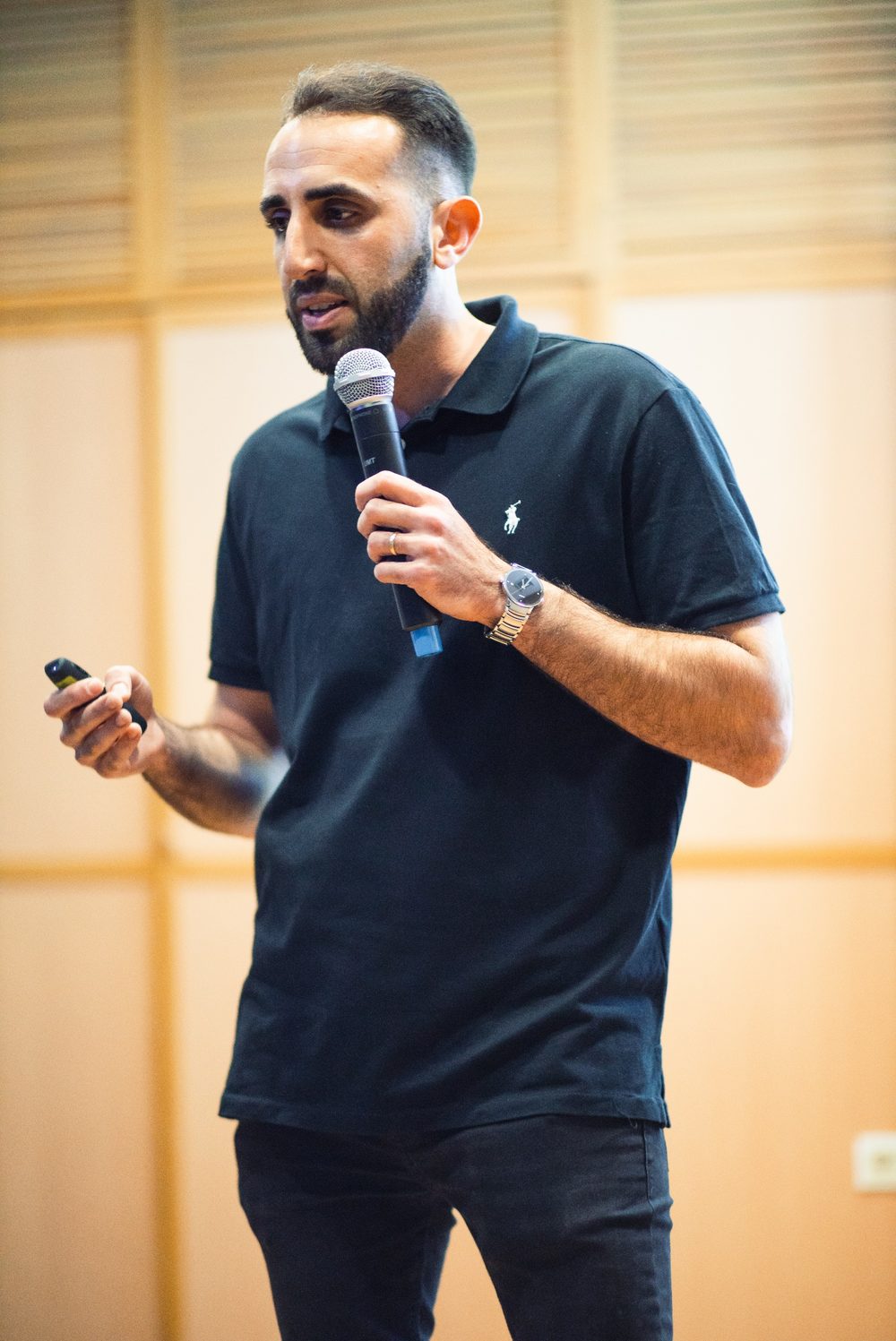 תומר פולת מרצה על הבמה עם מיקרופון